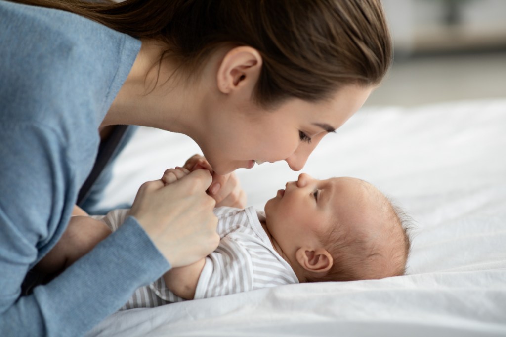 Eine glückliche Mutter spielt mit ihrem Baby.