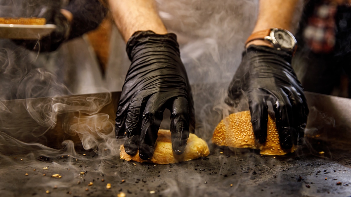 Hamburgerbrötchen, die mit der Vorderseite nach unten auf einem heißen Grill getoastet werden