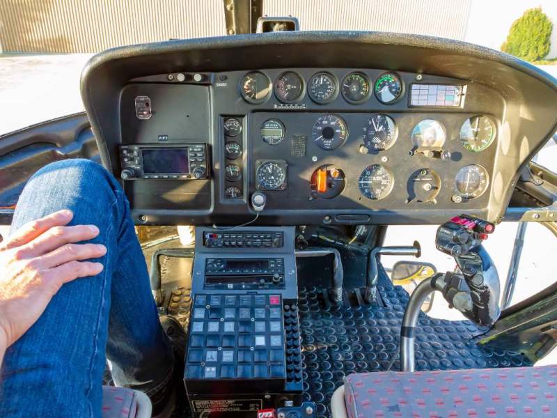 Ein Mann sitzt im Cockpit eines Helikopters.